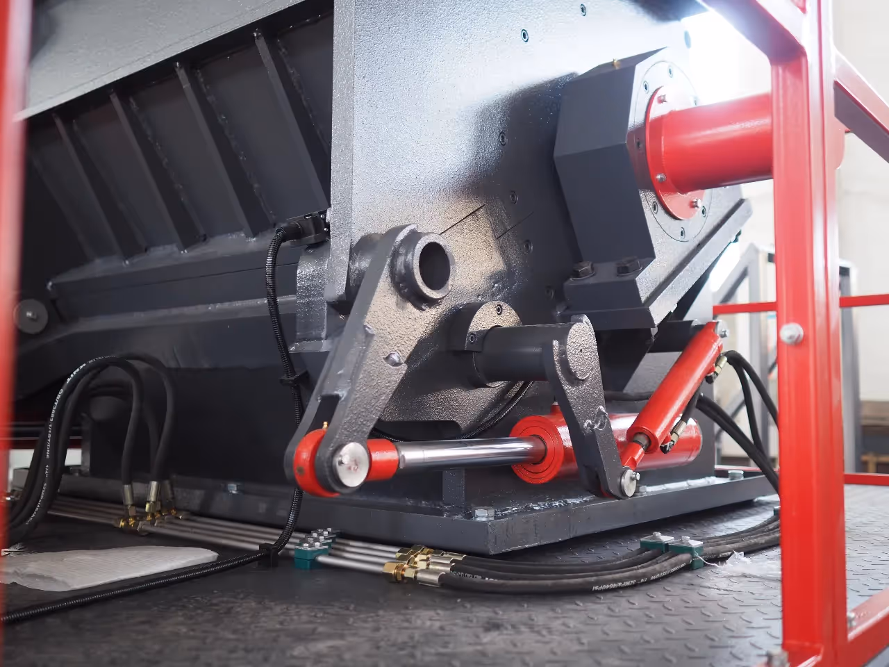 The hydraulic opening system of a heavy-duty plastic crusher, showing the powerful hydraulic cylinder used for easy access during maintenance.